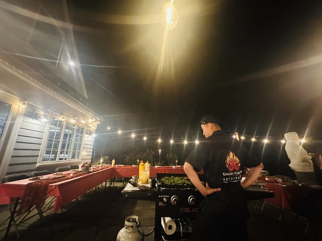 Best Hibachi Catering chef performing a live hibachi show in a Bronxville backyard under string lights.
